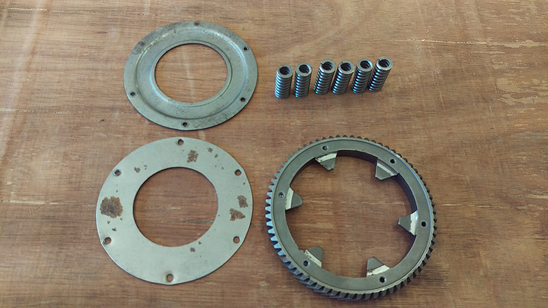 Here are the components of the cush drive, less the center section. The 68T primary driven gear, the six coil springs which fit between the inner ears of the gear, and the side plates. The embossed one fits on the same side as the bevel on the gear.
