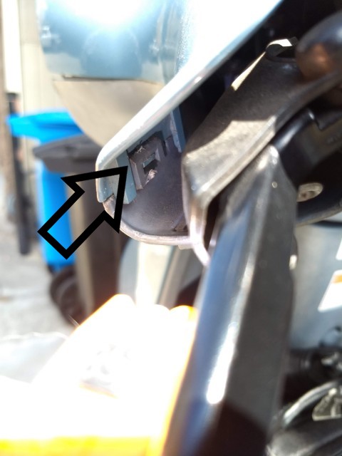 There are 3 plastic clips holding the top instrument bezel. One by each grip and one at the rear of the bezel. Use a flat blade screwdriver and gently pry the clip apart. Be careful to not break the clips off.